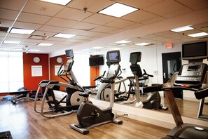 A gym with multiple exercise machines, a treadmill, and a mirrored wall. - Holiday Inn Express and Suites Overland Park by IHG (Overland Park)