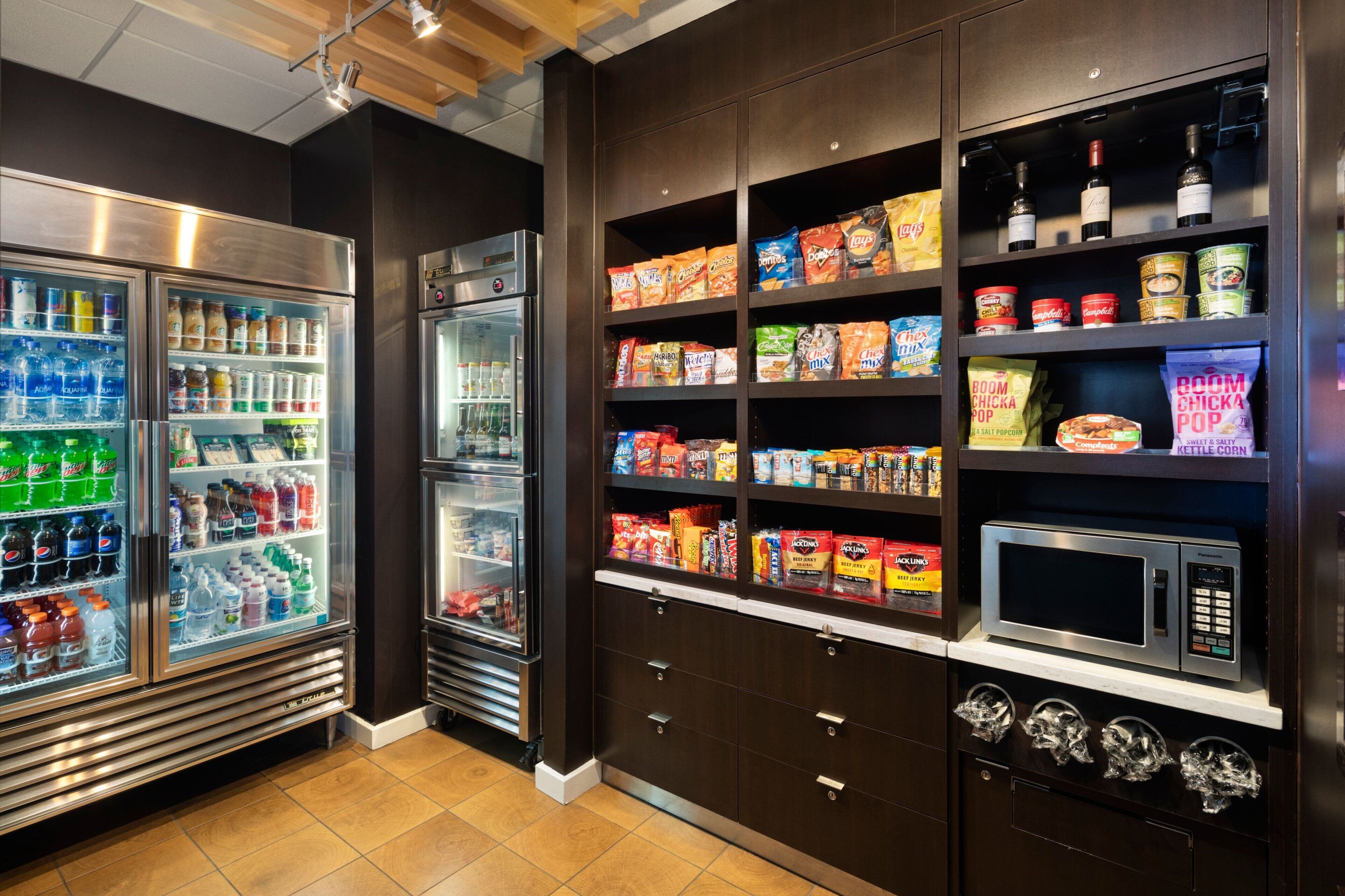 A well-stocked snack and beverage refrigerator area with various drinks and snacks.