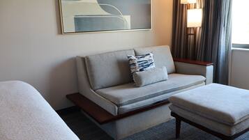 Ein Hotelzimmer mit einer Couch, einem kleinen Tisch und einem Bett.