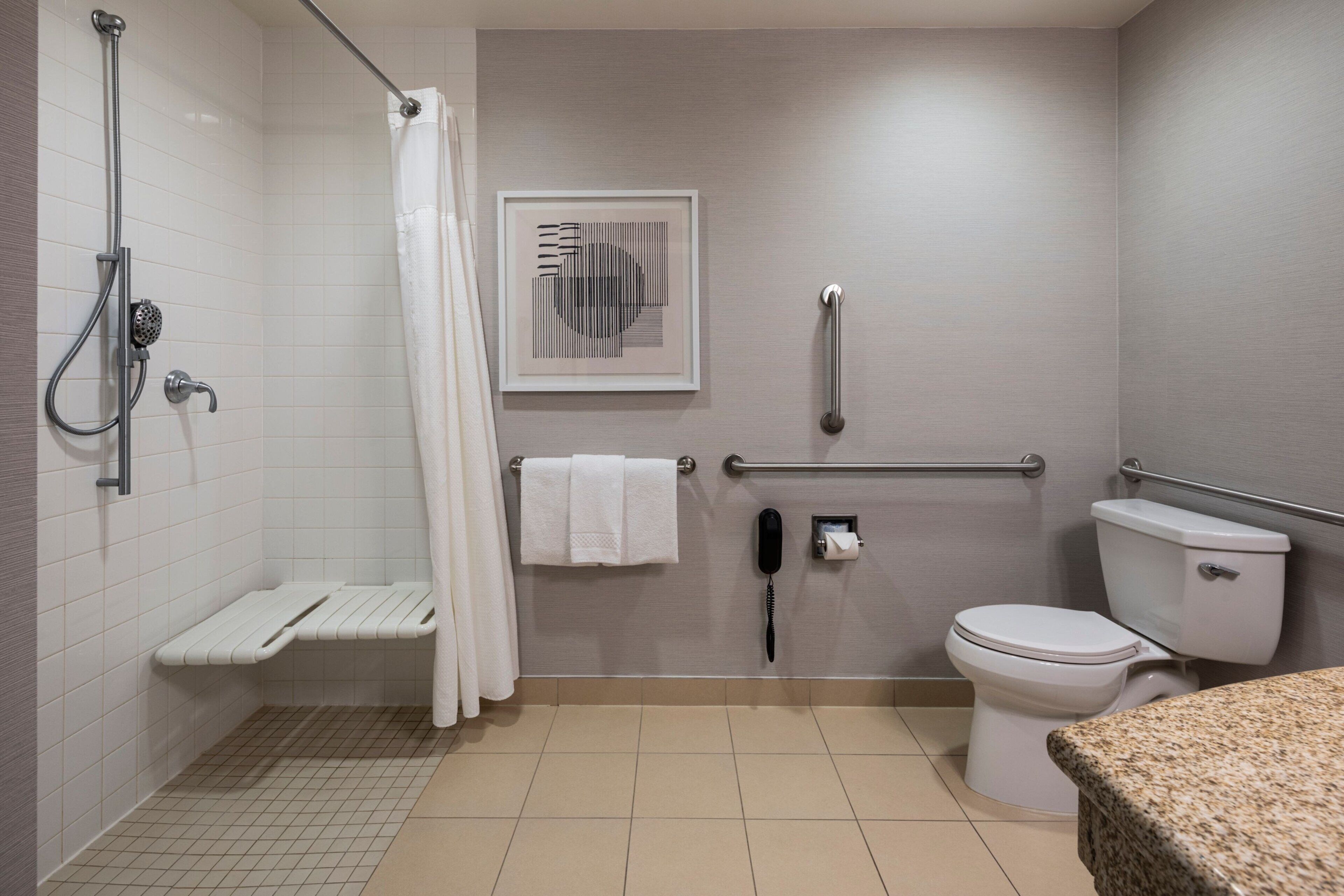 A modern bathroom with a shower, toilet, and a sink area.