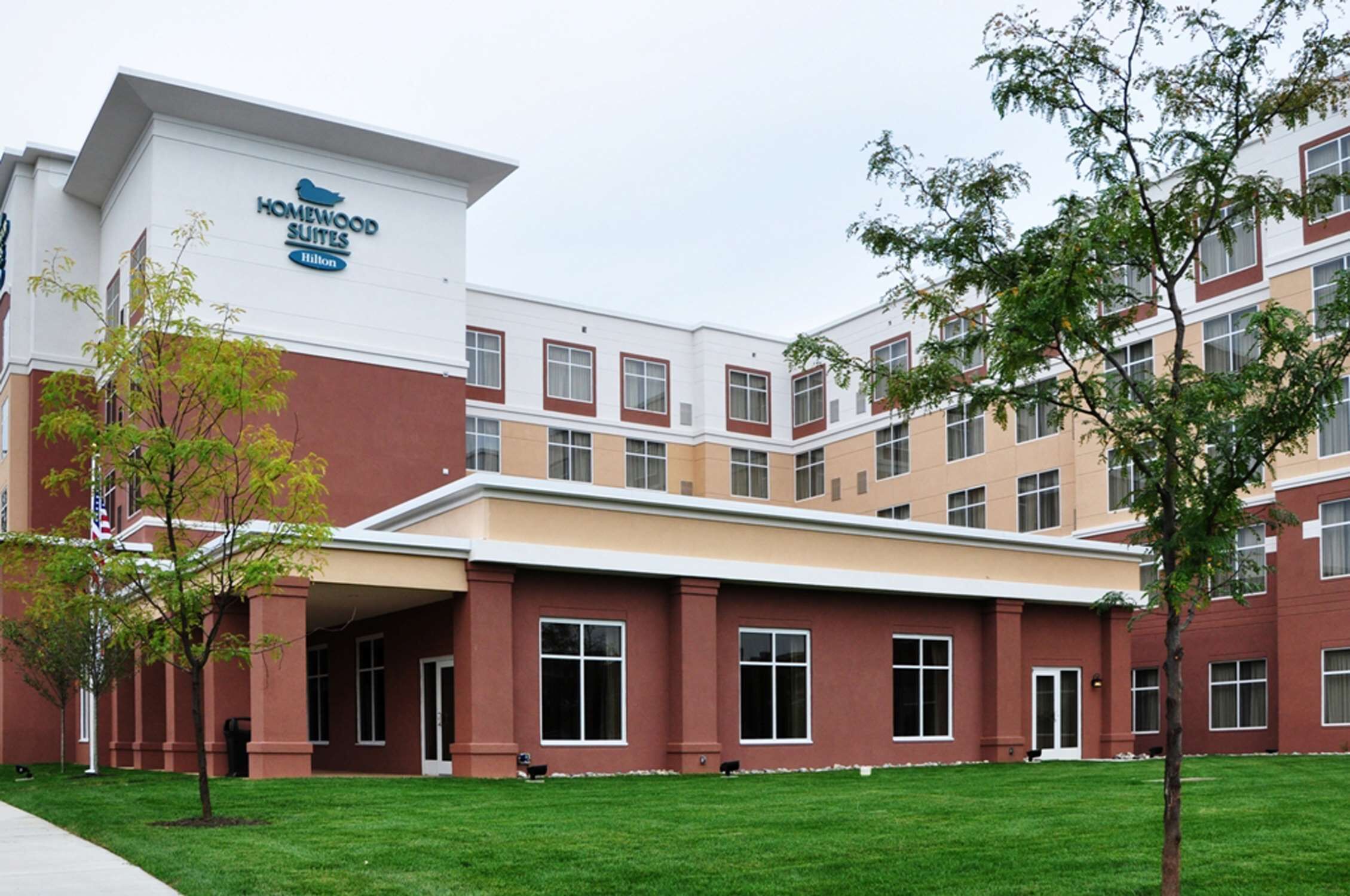 Un hôtel moderne, reconnaissable à son grand panneau « Homewood Suites ».