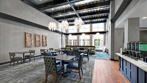 A spacious dining area with multiple tables and chairs, a coffee station, and large windows providing natural light. - Homewood Suites by Hilton Doylestown (Warrington)