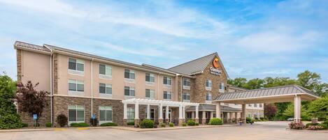 A hotel with a covered entrance, multiple windows, and a stone facade.