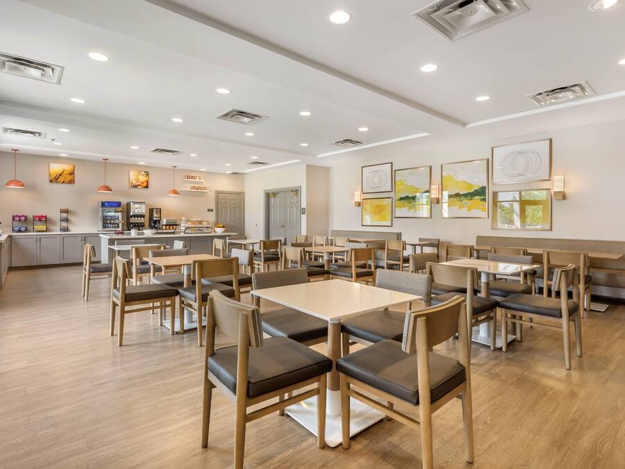 A modern restaurant with wooden furniture, recessed ceiling lights, and artwork on the walls.