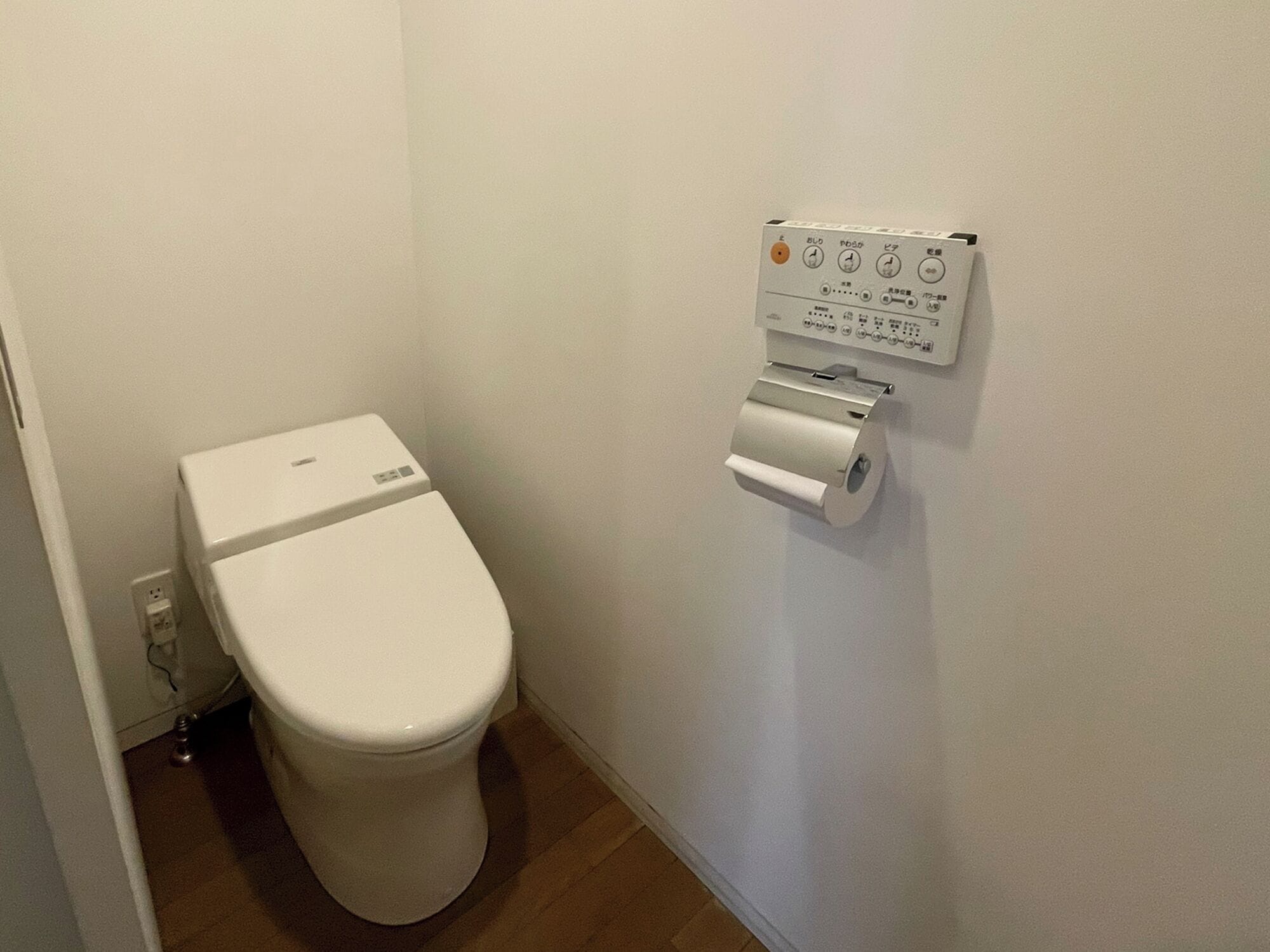 A toilet with a wall-mounted flush system.