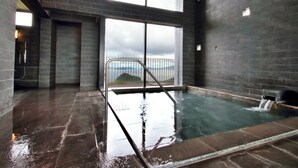 Ein moderner, überdachter Pool mit Blick auf die Berge durch große Fenster.