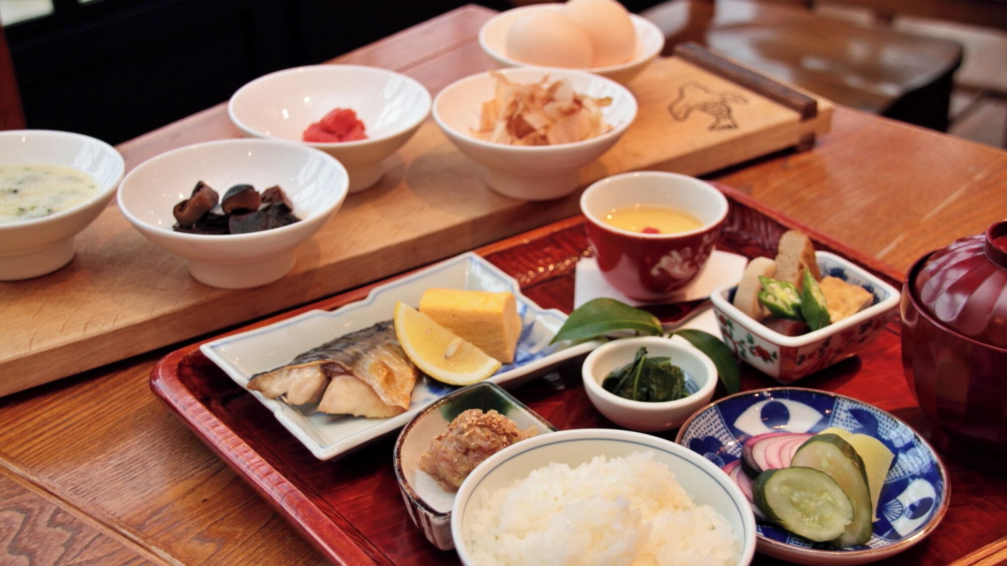 Una comida tradicional japonesa con diversos platos sobre una mesa de madera.