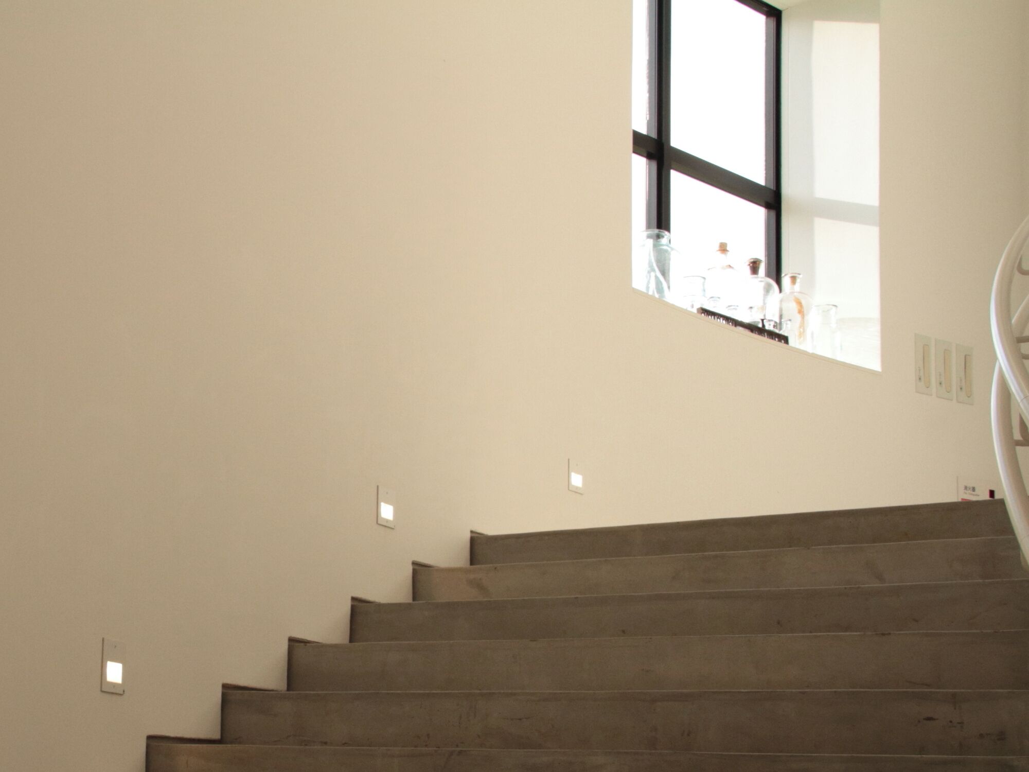 Uma escadaria com vista para um quarto através de uma janela.