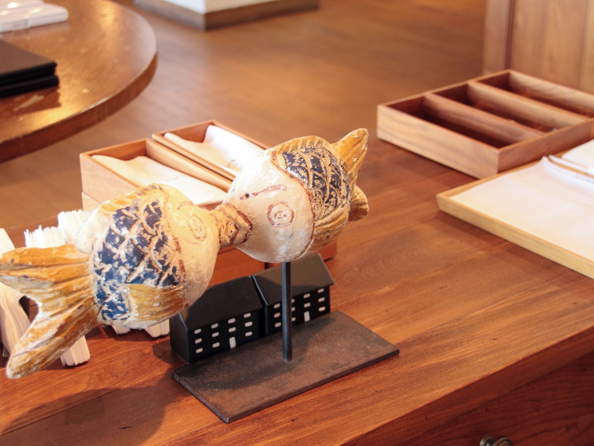 A wooden counter with a decorative pig sculpture and a black stand.