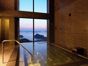 A modern spa room with a large glass door leading to a view of the sea. - Margherita Goto Islands Resort Hotel (Shinkamigoto)