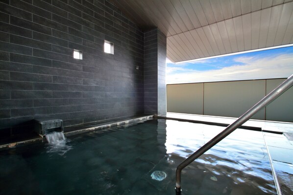 A spa area with a dark tiled wall, a small window, and a metal railing. - Margherita Goto Islands Resort Hotel (Shinkamigoto)