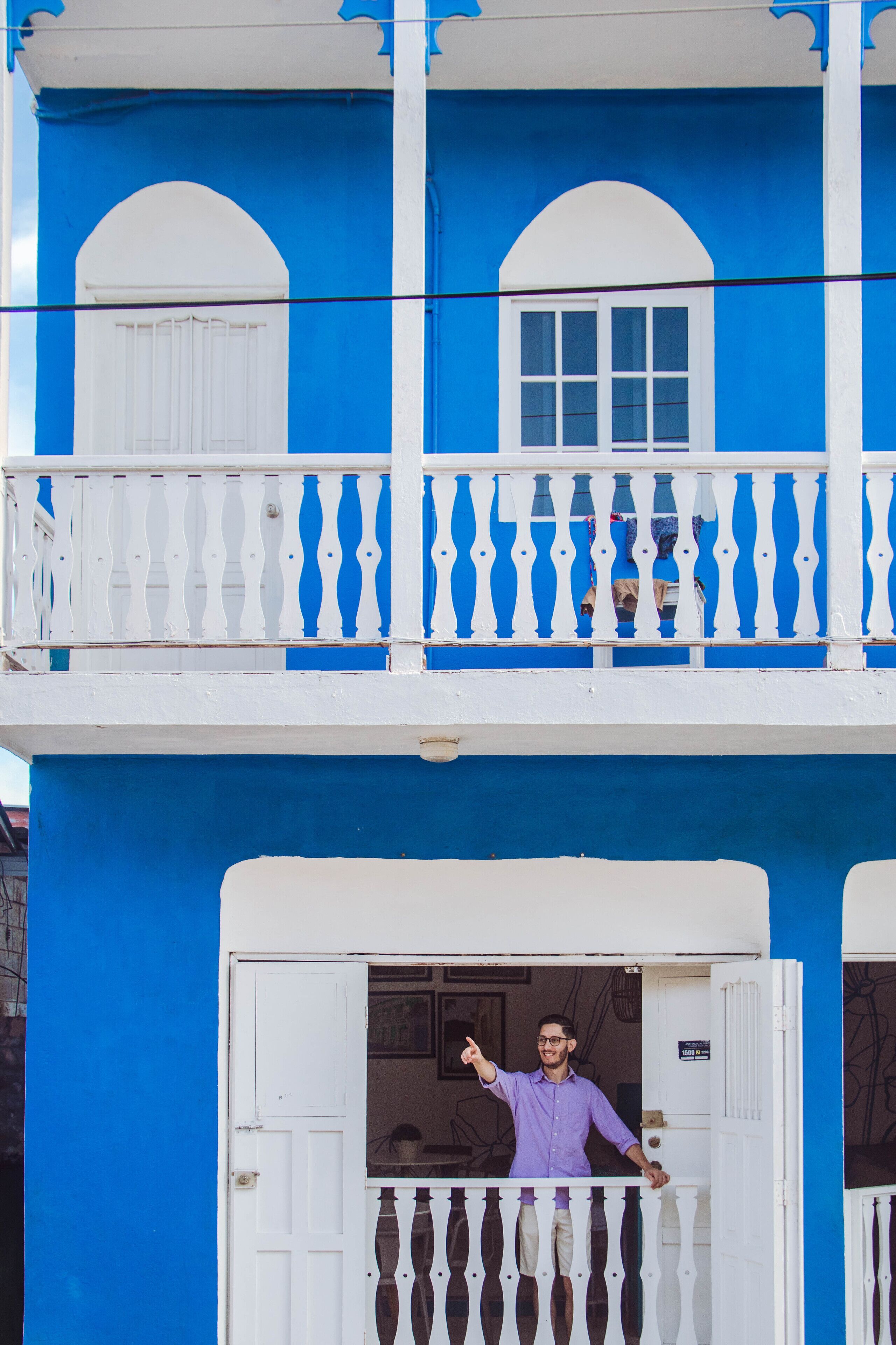 A two-story building with a balcony and a door.