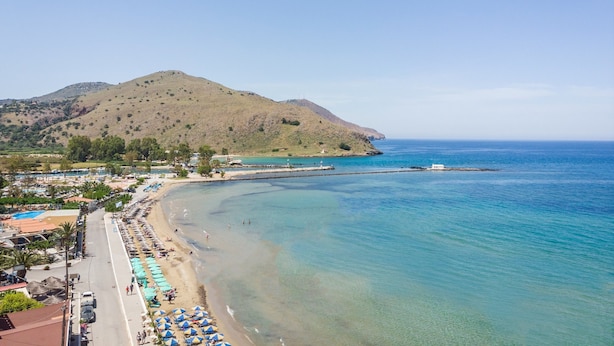 A coastal area with a beach, clear blue waters, and a hilly landscape in the background. - Mare Boutique - Adults Only (Apokoronas)