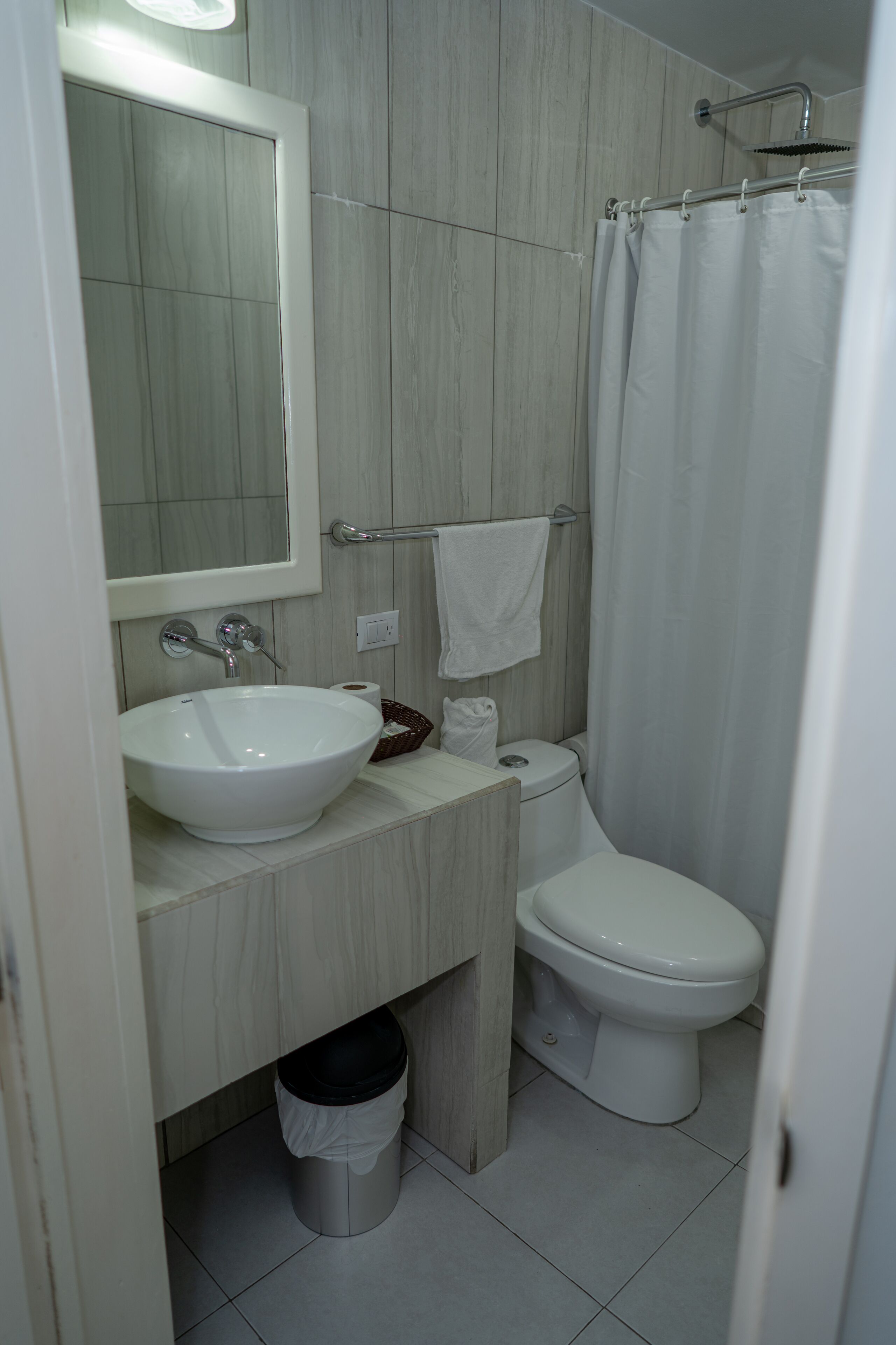 A bathroom with a white sink, a toilet, and a shower curtain.