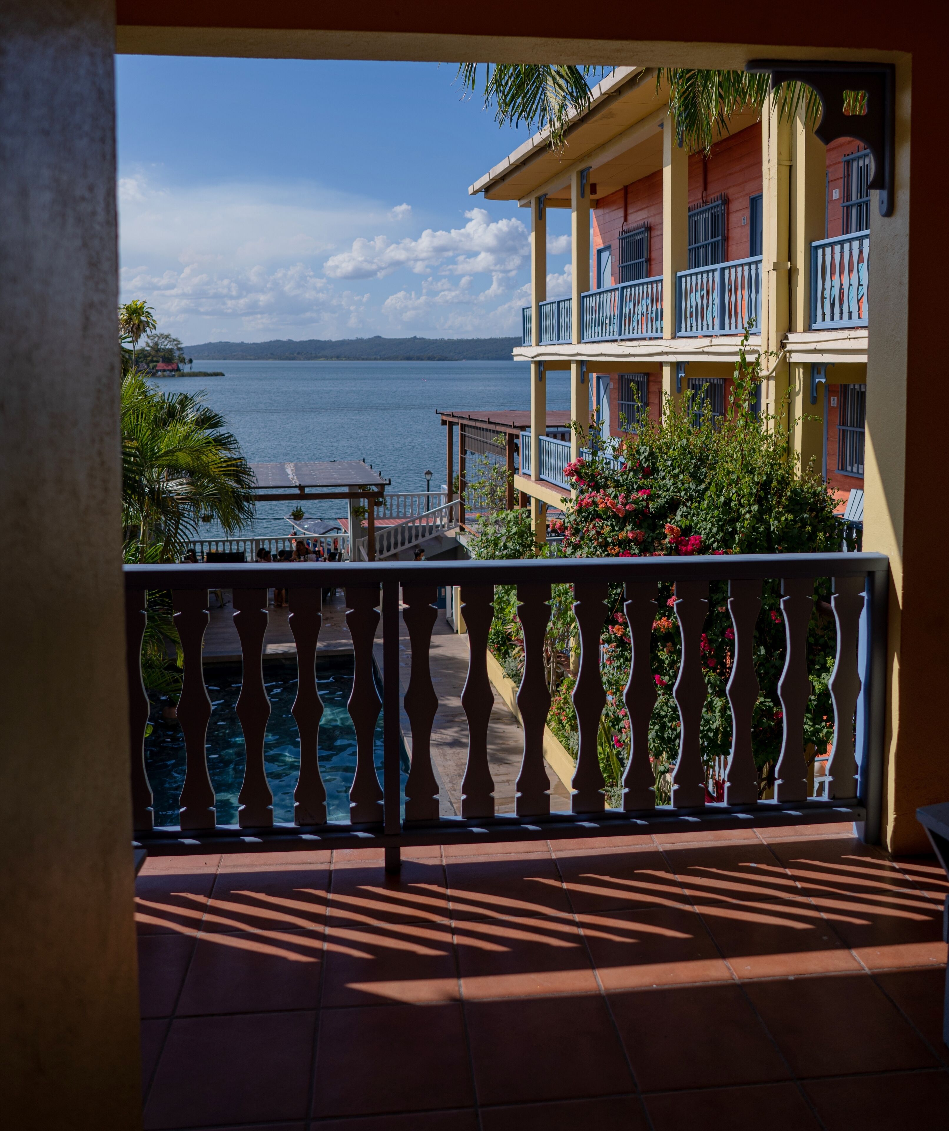 Un balcón con vista a un cuerpo de agua y un edificio con balcones.