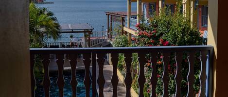 A balcony with a view of a body of water and a building with balconies.