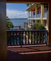 Un balcón con vista a un cuerpo de agua y un edificio con balcones.