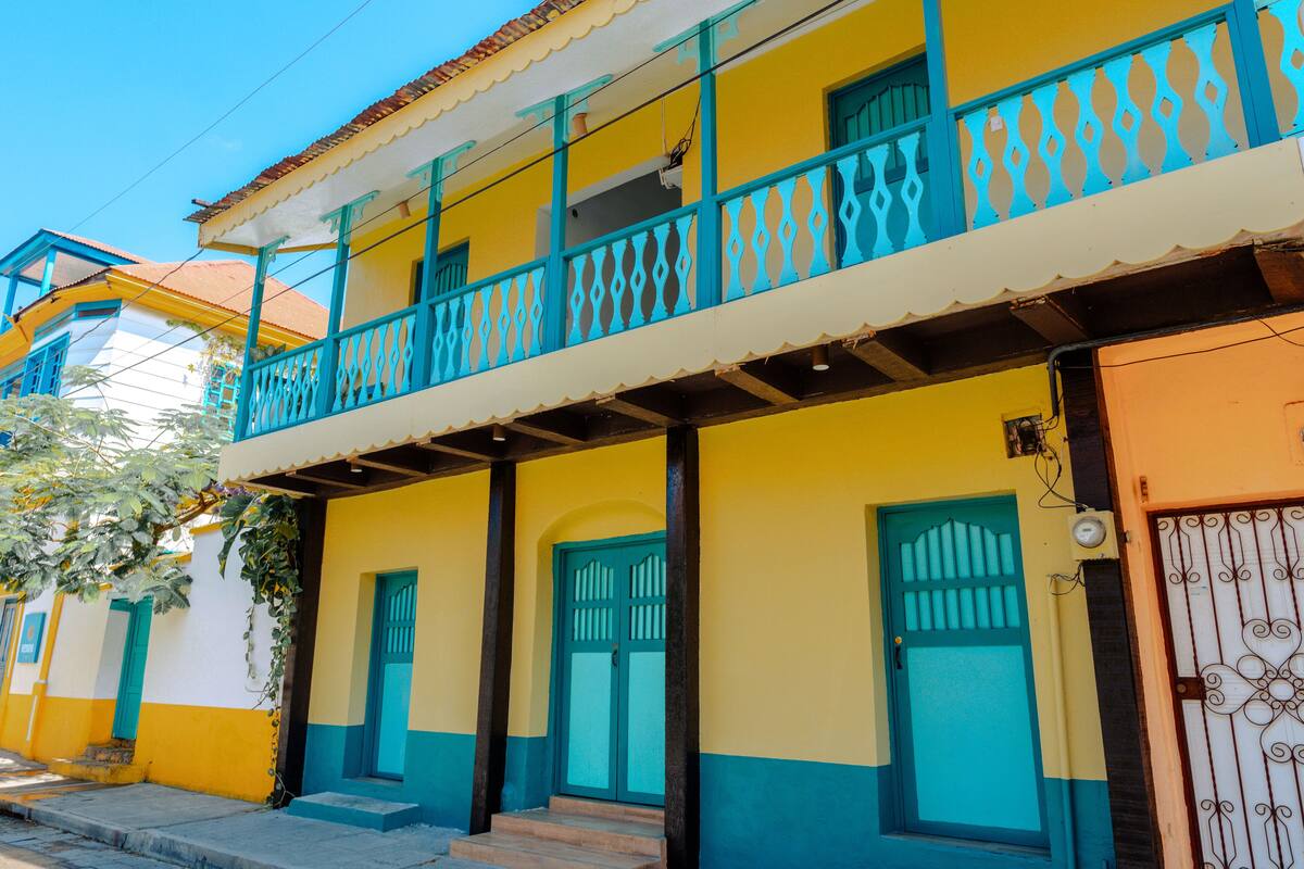 Un edificio de dos pisos con un balcón, una puerta y una ventana.