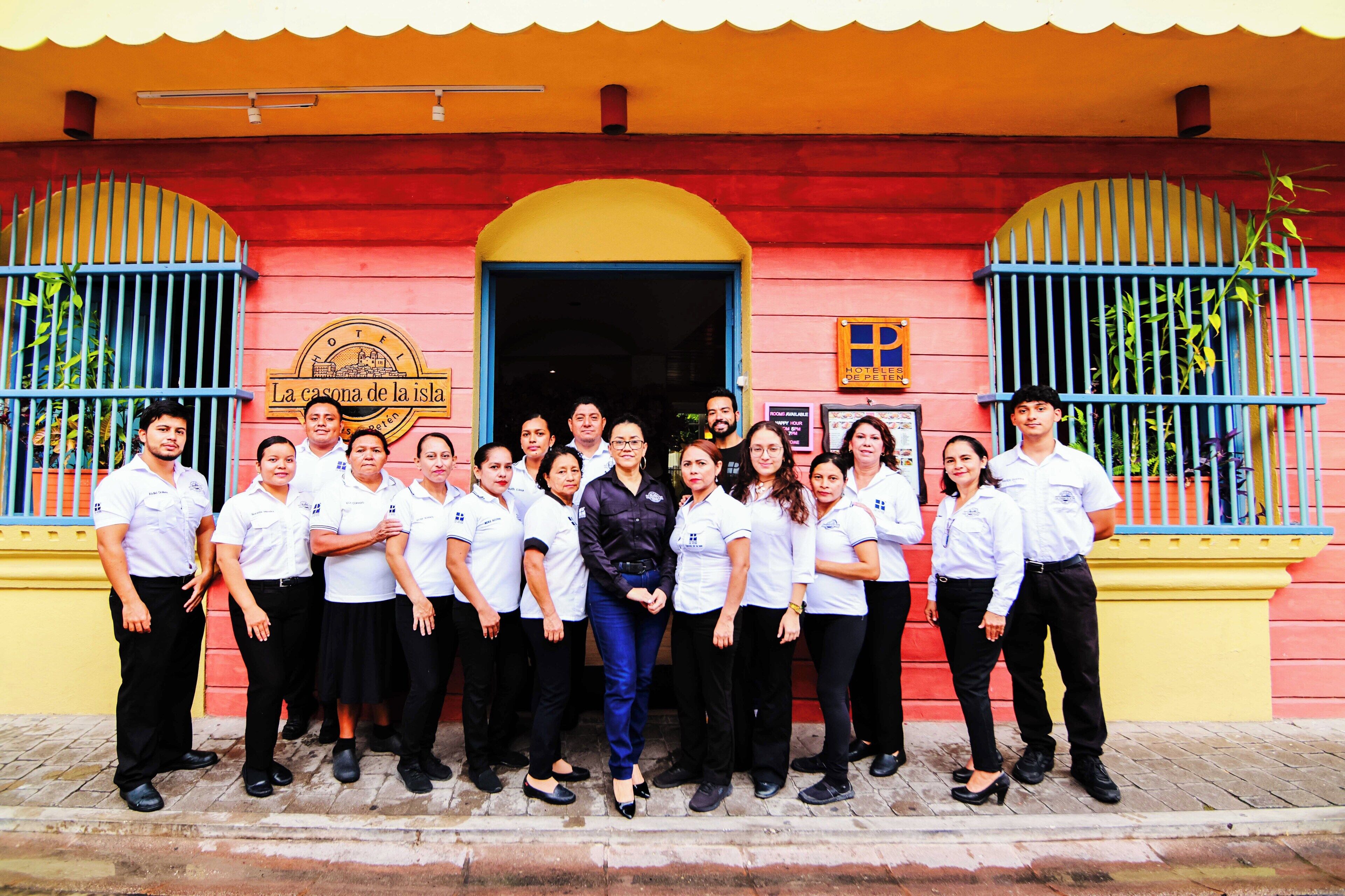A group of people standing in front of a building with a sign that reads "Hotel La Casona de la Isla."