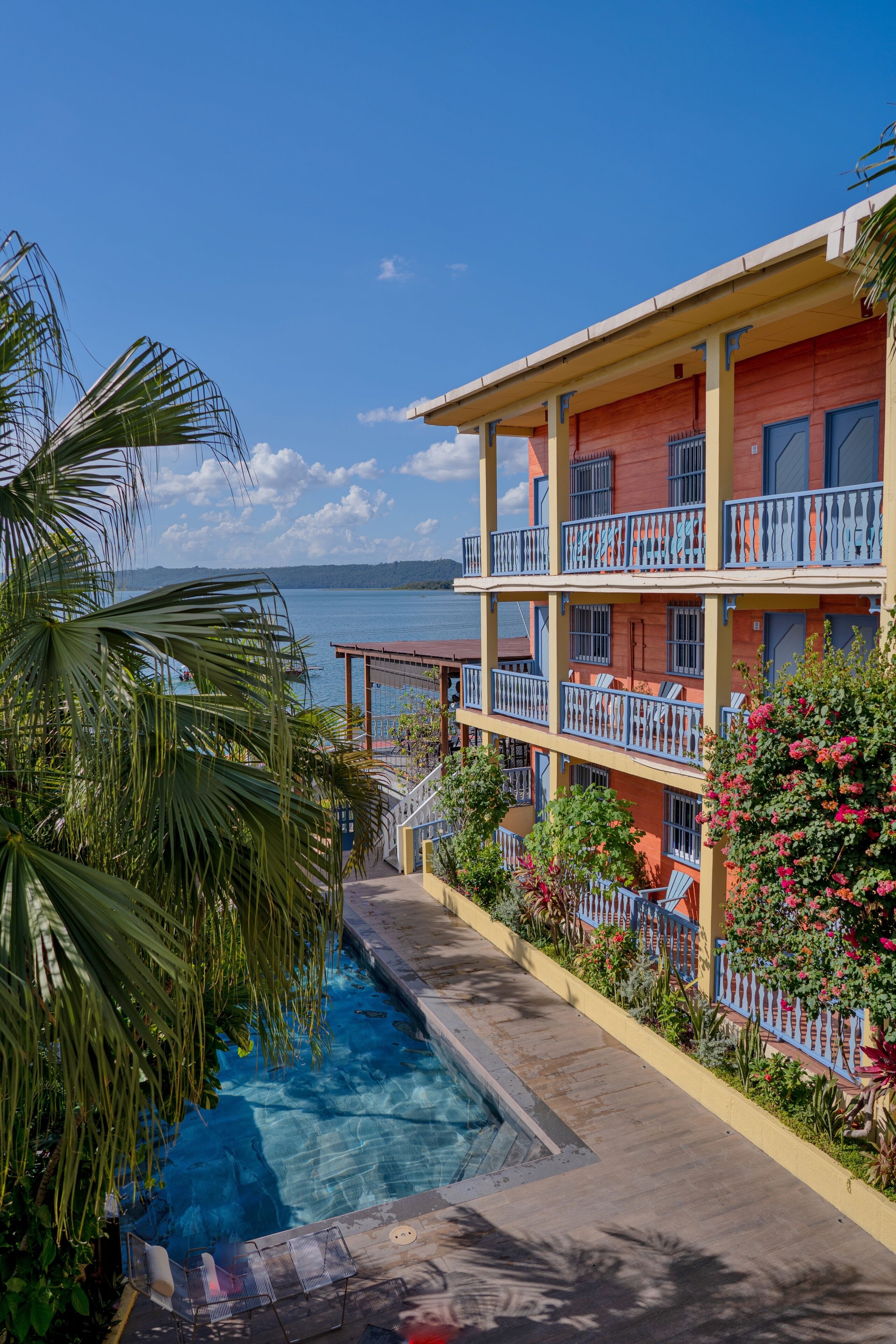 Un hotel de varios pisos con balcones, piscina y vista al mar.