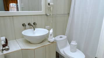 Une salle de bain avec un lavabo blanc, des toilettes et un rideau de douche.
