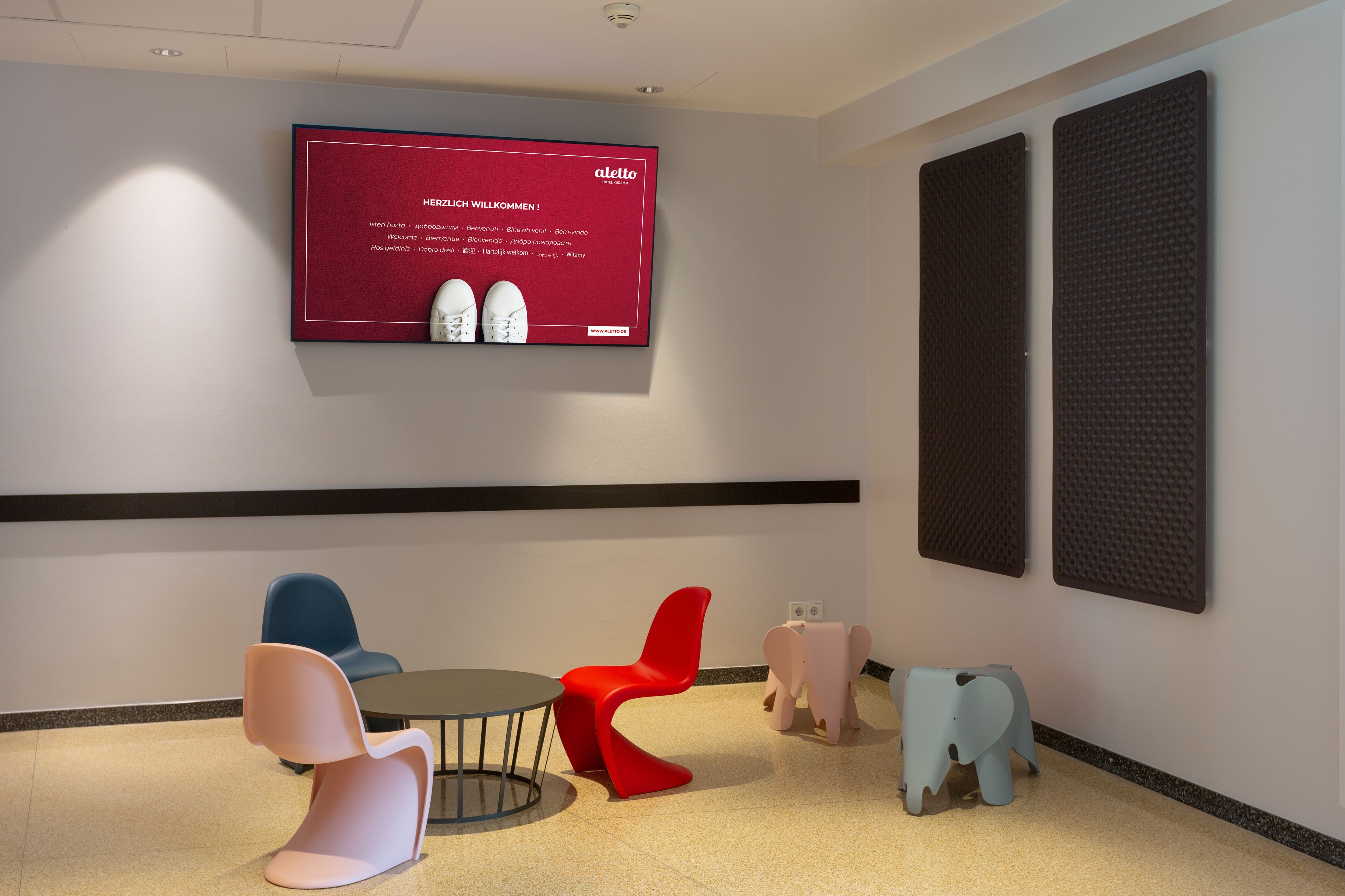 Een modern interieur met een rode welkomstscherm, een ronde tafel en stoelen in een bijzondere vorm.