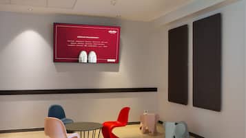 Een modern interieur met een rode welkomstscherm, een ronde tafel en stoelen in een bijzondere vorm.