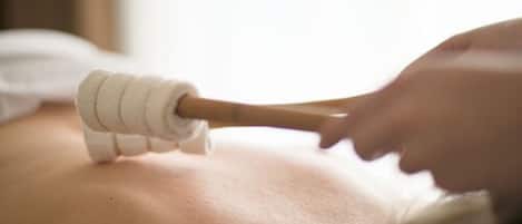 A close-up of a massage tool being used on a person's back.