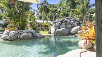 Una piscina al aire libre, sillones reclinables de piscina