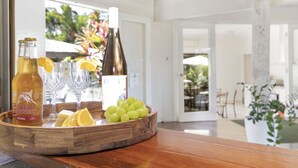 Ein Holztisch mit einer Weinflasche, Gläsern und Obst.