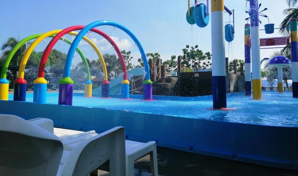 Een waterpark met kleurrijke glijbanen en een zwembad.