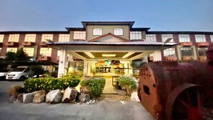 A hotel with a traditional architectural style, featuring a central entrance, multiple windows, and a parking area with a fire hydrant. - De Baron Resort (Langkawi)