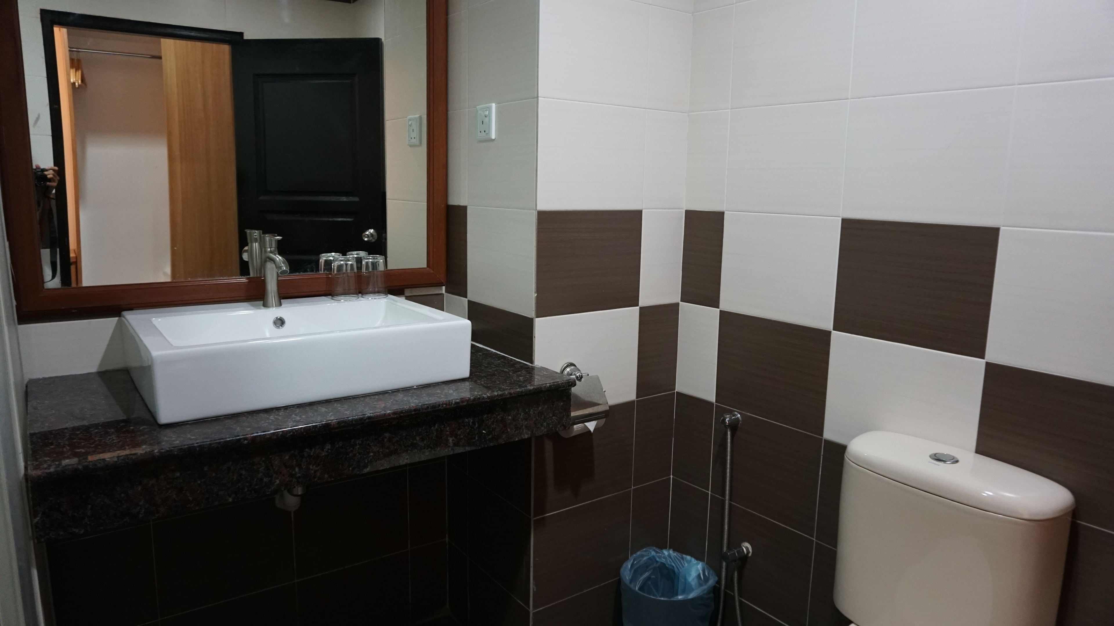 A bathroom with a white sink, a mirror, and a toilet.
