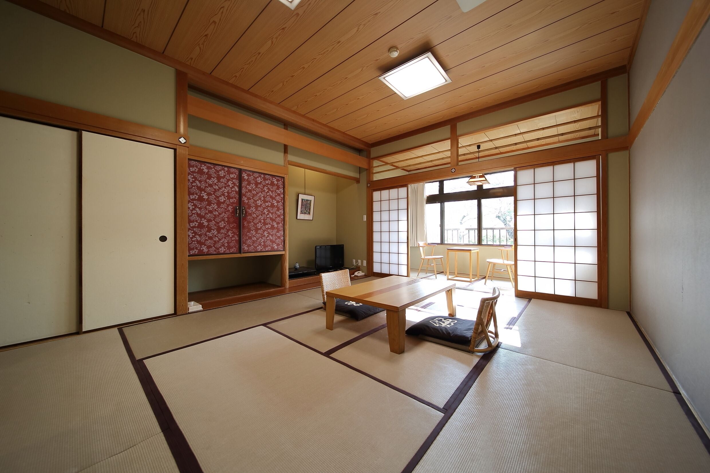 Une pièce de style japonais traditionnel, avec un sol recouvert de tatamis, une basse table en bois et des portes coulissantes.
