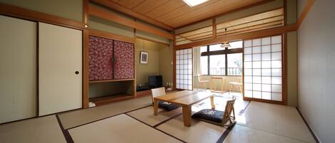Une pièce de style japonais traditionnel, avec un sol recouvert de tatamis, une basse table en bois et des portes coulissantes.
