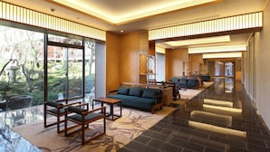 A spacious lobby with a sofa, chairs, and a reception desk. Large windows offer a view of the outdoors. - Ryokan Nenrinbo (Kyoto)