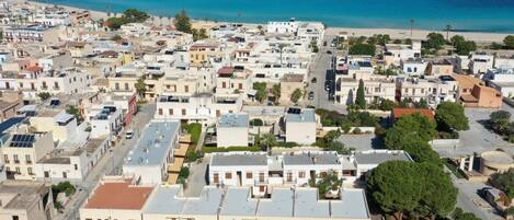 A coastal town with a mix of residential buildings and a beach in the background.