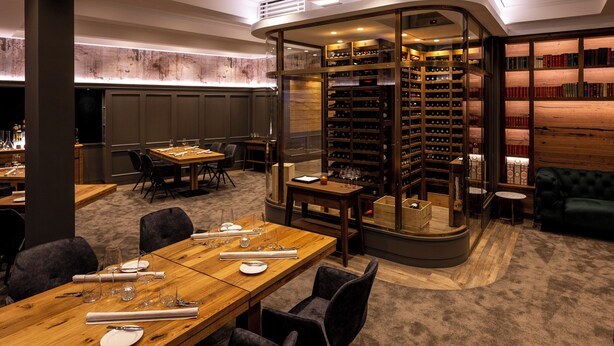 A conference room with a long table, chairs, and a glass partition with bookshelves. - Ratshotel (Haltern am See)