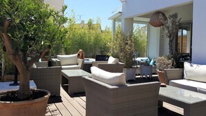 An outdoor seating area with wicker furniture, potted plants, and a sign reading "SPA". - Hôtel Sable et Soleil (Fréjus)