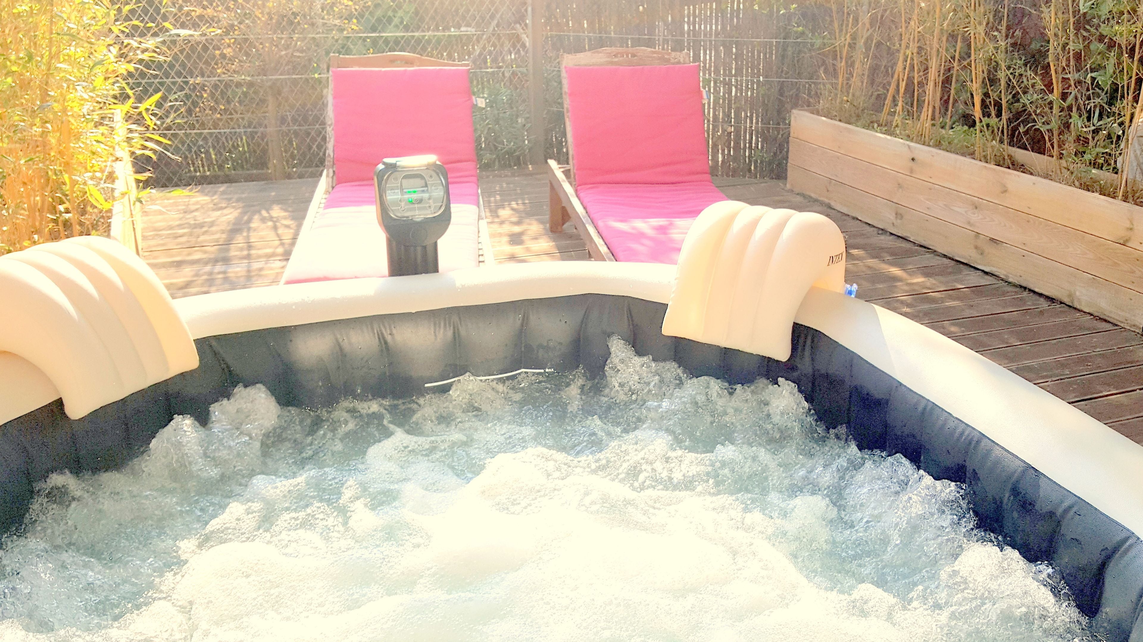 Un jacuzzi con dos sillones reclinables rosados y un panel de control.