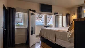 A bedroom with a bed, a TV, and a skylight. - La Suite Villa (Trois-Ilets)