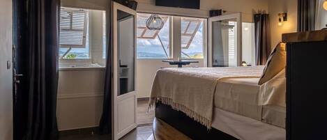Un dormitorio con cama, televisor y tragaluz.