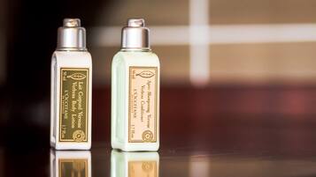 Two bottles of body lotion and conditioner on a reflective surface.