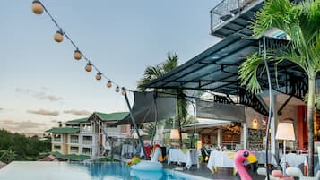 Relax by the pool surrounded by palm trees and comfortable seating areas.