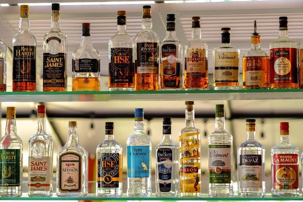 Two shelves of various liquor bottles.