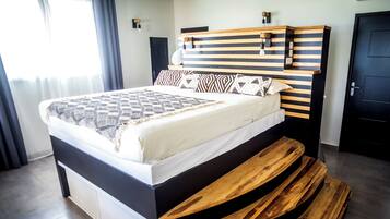 Una camera da letto moderna con un letto, una testiera in legno e una panca integrata.
