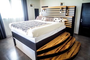 Una camera da letto moderna con un letto, una testiera in legno e una panca integrata.