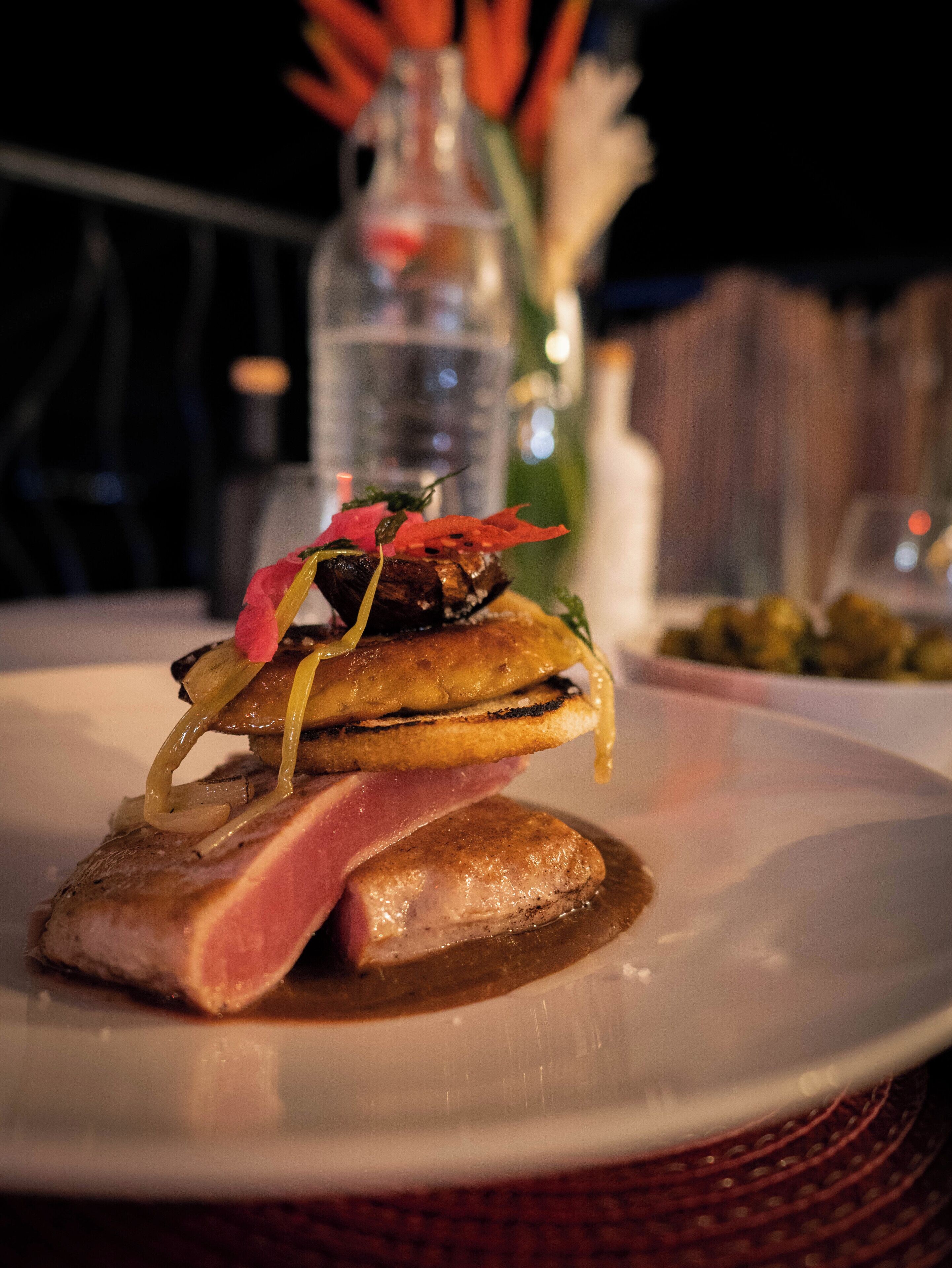 Une assiette contenant un plat composé de viande, de légumes et d’une sauce.