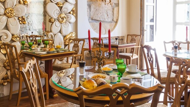 Un espace repas agrémenté de décorations murales raffinées, d’un mur en pierre et d’une table mise pour le repas.
