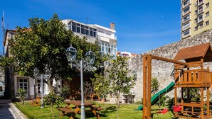 Un parc avec des tables de pique-nique, une balançoire et un lampadaire.